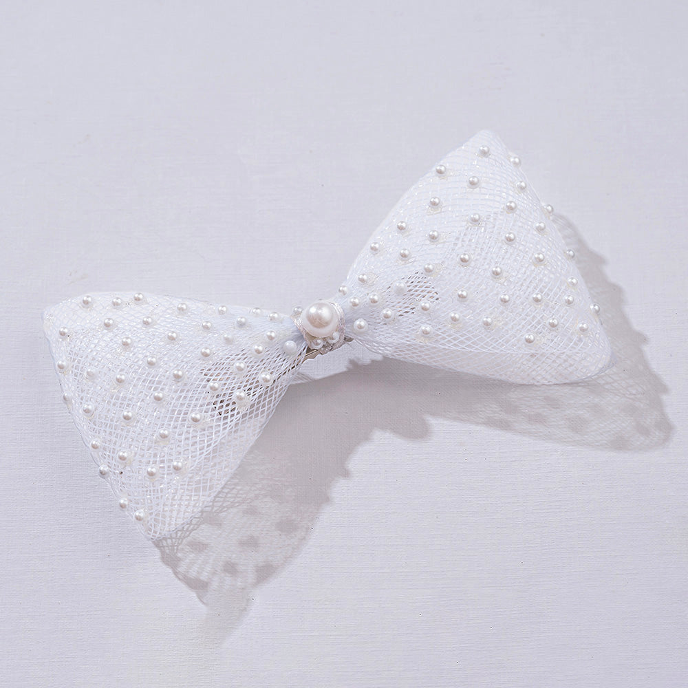White bow hair accessory with pearls on a light gray background, featuring the brand 'Hair Drama Co.'